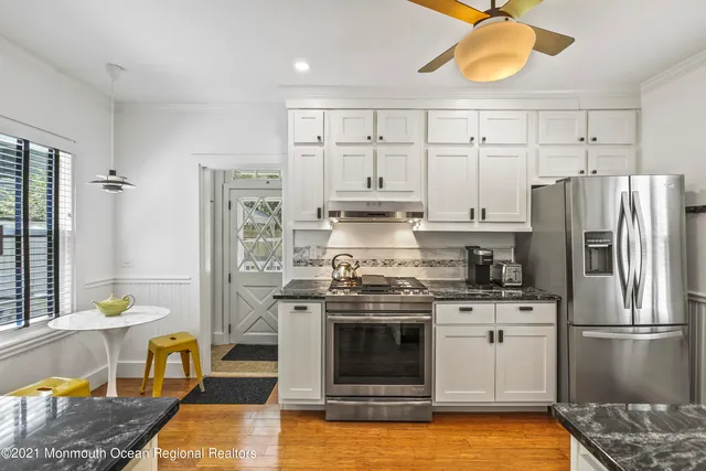 a kitchen with stainless steel appliances granite countertop a stove a refrigerator and a stove