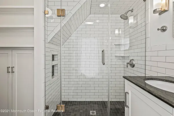 a bathroom with a granite countertop sink a toilet and shower