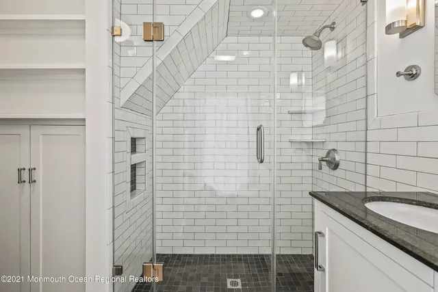 a bathroom with a granite countertop sink a toilet and shower
