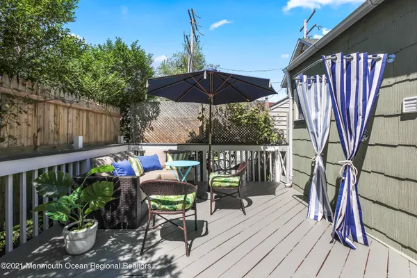 a balcony with wooden floor table and chairs