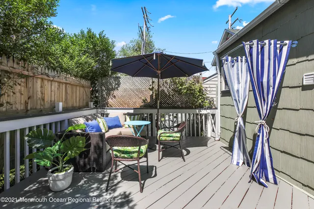 a balcony with wooden floor table and chairs