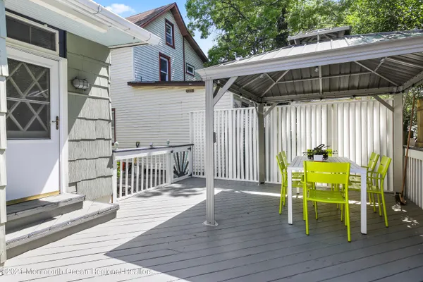 a view of deck with table and chairs with wooden floor and fence