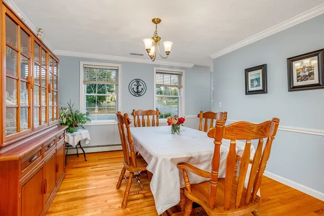 a view of a dining room with furniture a chandelier and wooden floor