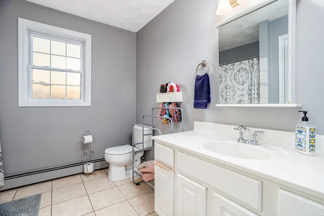 a bathroom with a sink toilet and a window