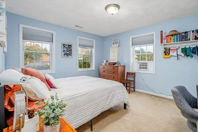 a bedroom with a bed a dresser and a window
