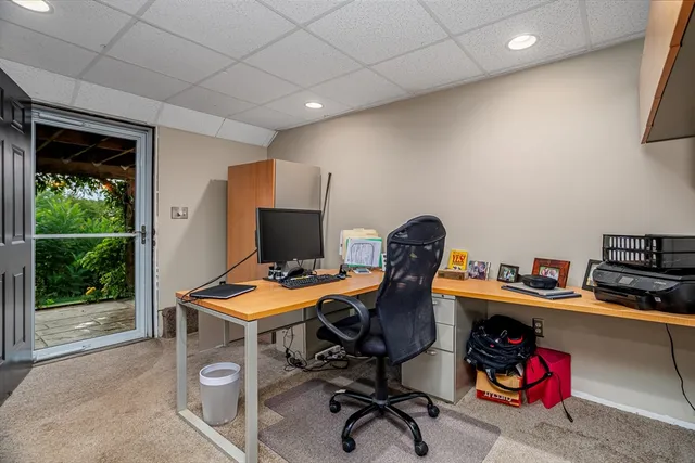 a view of a workspace with furniture and a window