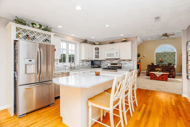 a kitchen with stainless steel appliances granite countertop a refrigerator and a stove top oven
