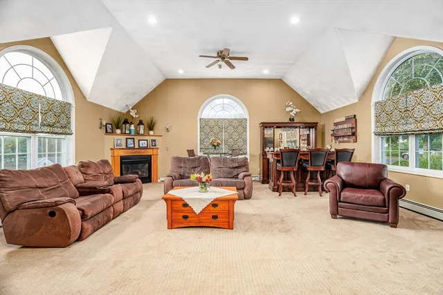 a living room with furniture fireplace and a large window
