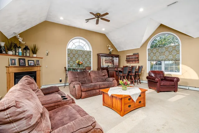 a living room with furniture fireplace and a large window