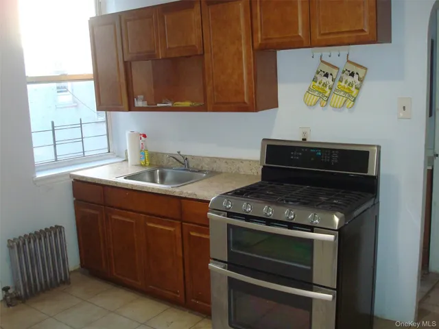 a kitchen with granite countertop a stove sink and cabinets