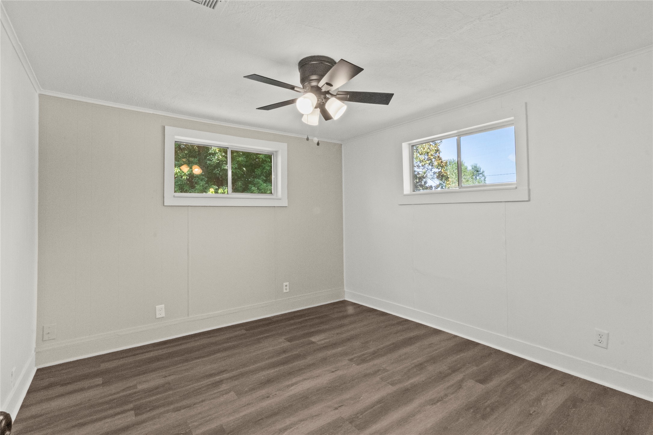 802 Collins Street Dayton, TX 77535 - Photo 3 of 12 a view of an empty room with wooden floor and a ceiling fan