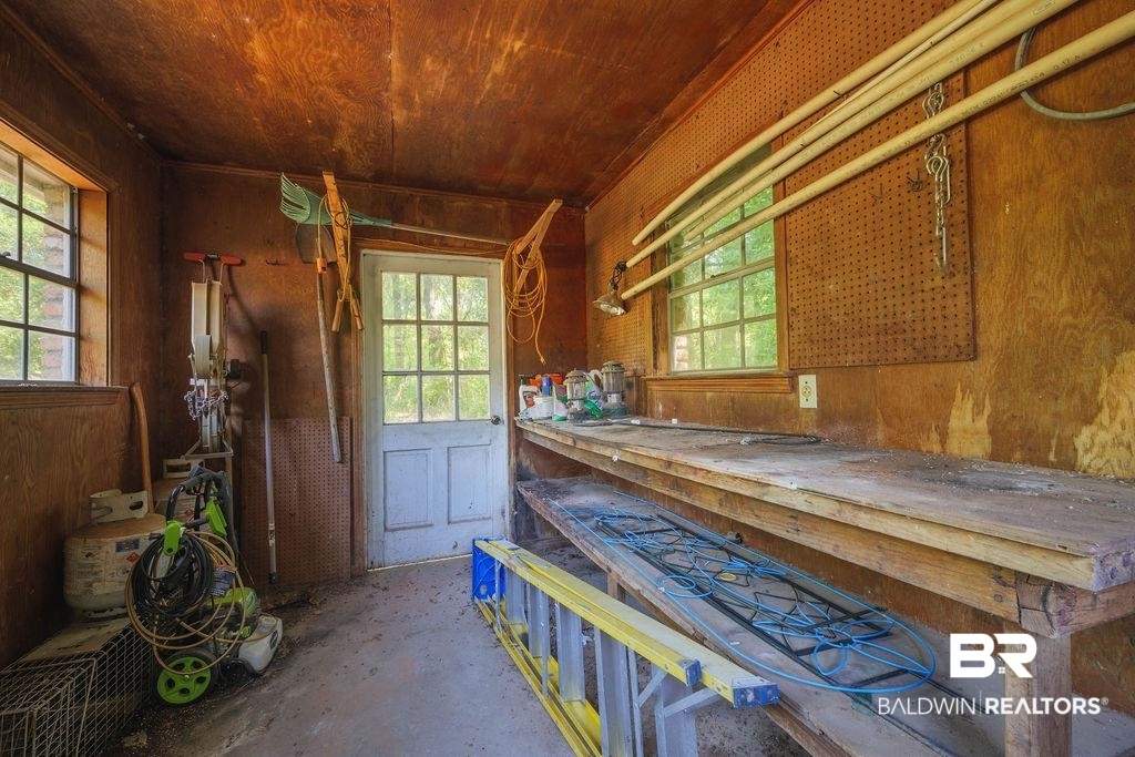 11901 Old Moffat Road Wilmer, AL 36587 - Photo 27 of 39 Misc room featuring wood walls, wooden ceiling, healthy amount of natural light, and unfinished concrete flooring