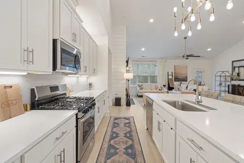 a kitchen with kitchen island a sink appliances and a dining table