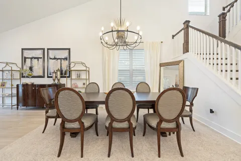 a view of a dining room with furniture and a chandelier