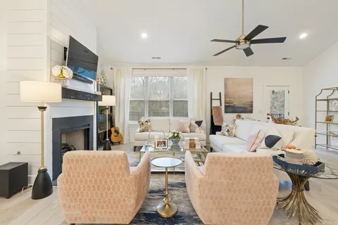 a living room with furniture kitchen view and a chandelier