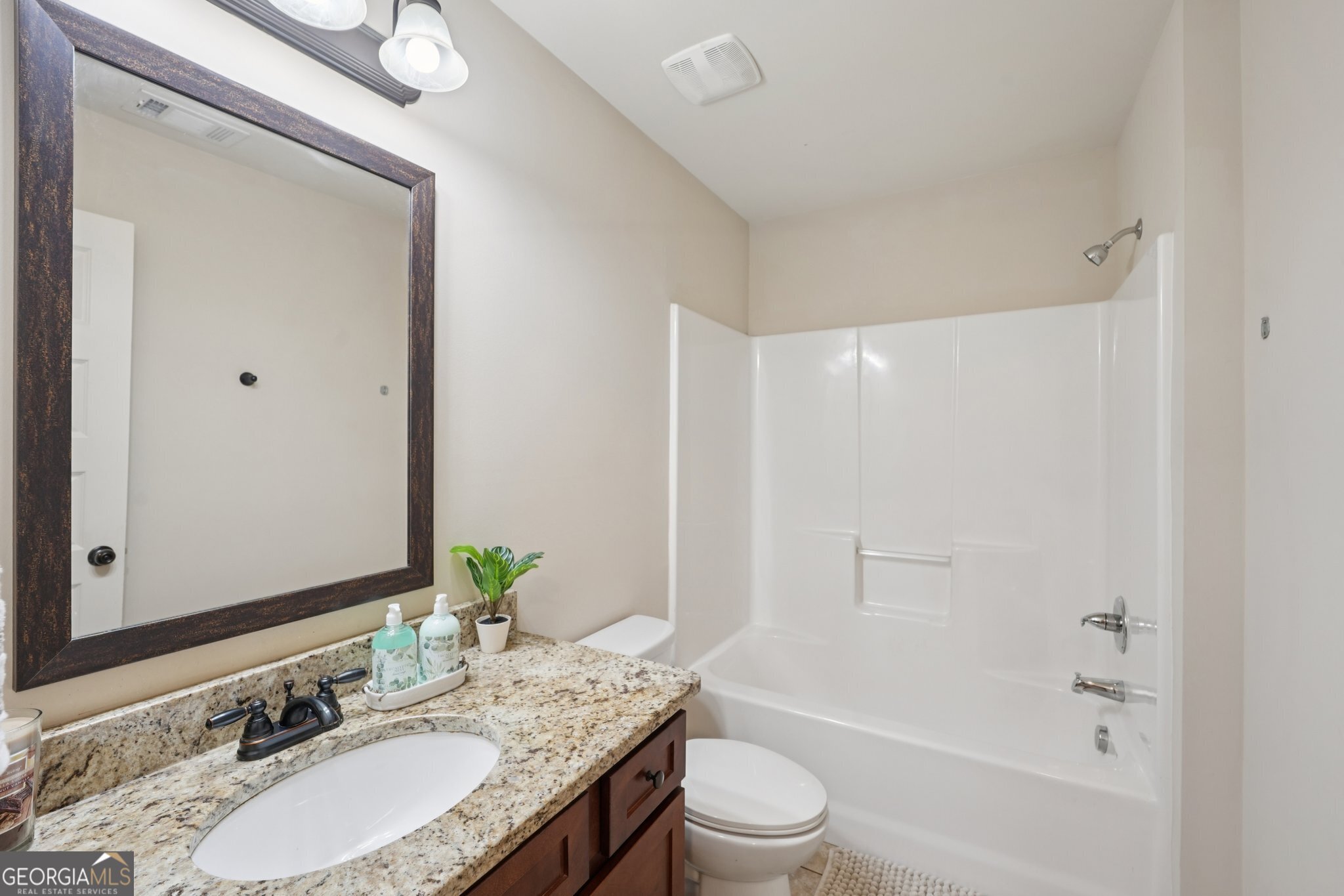 4007 Madison Acres Drive Locust Grove, GA 30248 - Photo 13 of 21 a bathroom with a granite countertop sink toilet and shower