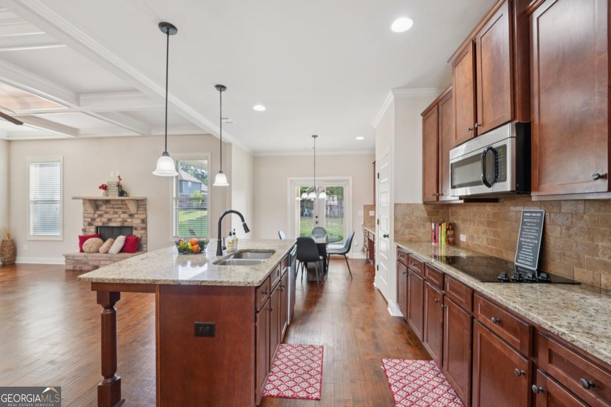 4007 Madison Acres Drive Locust Grove, GA 30248 - Photo 7 of 21 a kitchen with stainless steel appliances granite countertop a sink a stove top oven a chimney and cabinets