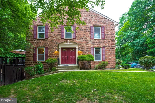 a front view of a house with garden and yard