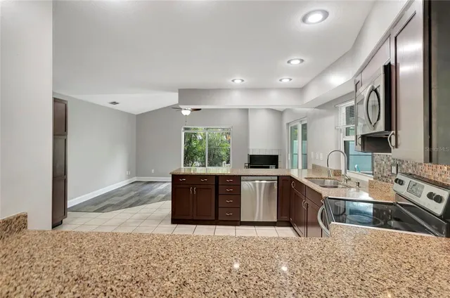 a kitchen with stainless steel appliances granite countertop a sink stove and refrigerator