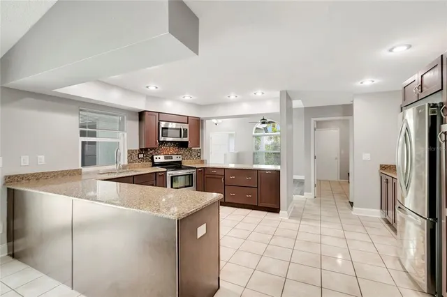 a kitchen with stainless steel appliances a refrigerator sink and microwave