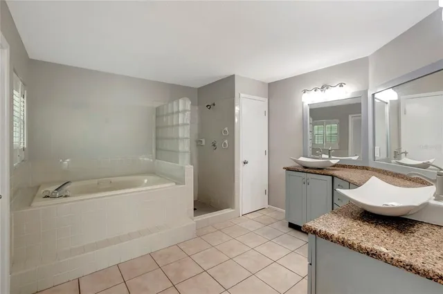 a spacious bathroom with a granite countertop tub sink and mirror