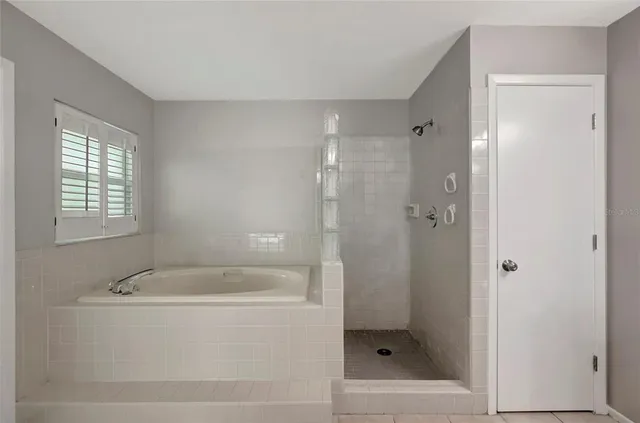 a white bath tub sitting next to a shower