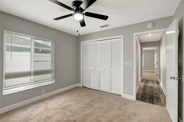 a view of a livingroom with a ceiling fan and window