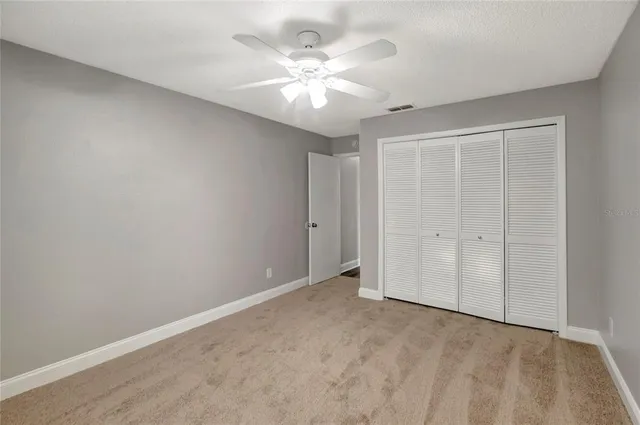 a view of an empty room with a ceiling fan