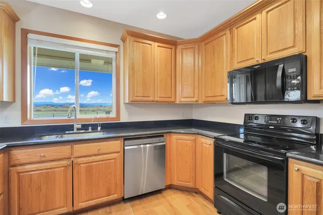 a kitchen with granite countertop a refrigerator stove and microwave