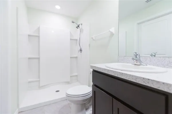 a bathroom with a sink a toilet and shower