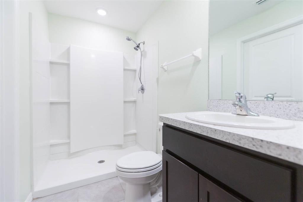 5358 Woodridge Lane Spring Hill, FL 34609 - Photo 26 of 32 a bathroom with a granite countertop sink toilet and shower