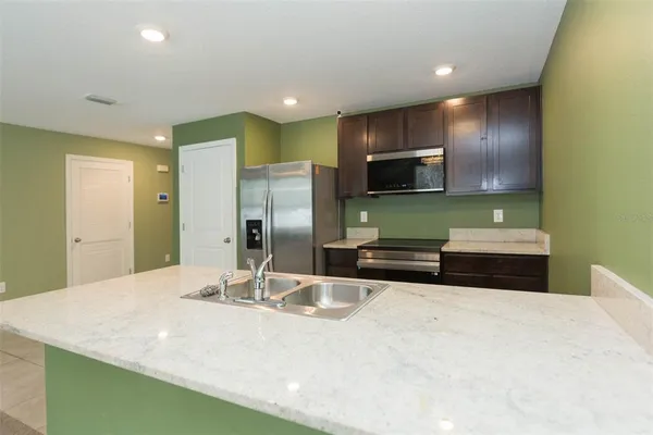 a kitchen with stainless steel appliances a sink and a refrigerator