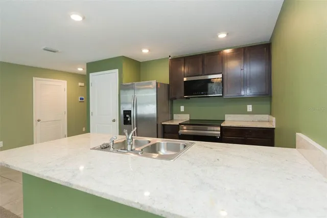 a kitchen with stainless steel appliances a sink and a refrigerator