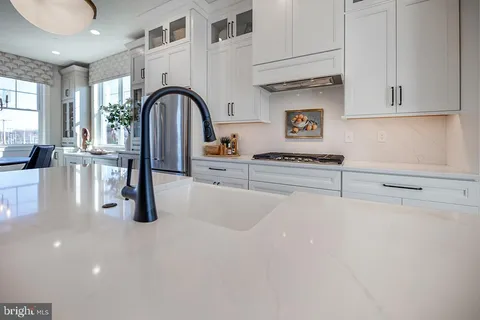 a kitchen with stainless steel appliances a table and cabinets