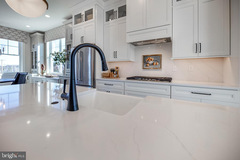 334 Foxtail Lane, Unit 22D Newtown Square, PA 19073 - Photo 14 of 22 a kitchen with stainless steel appliances a table and cabinets