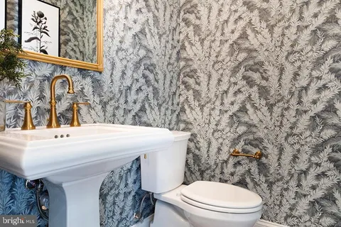 a bathroom with a toilet sink and mirror