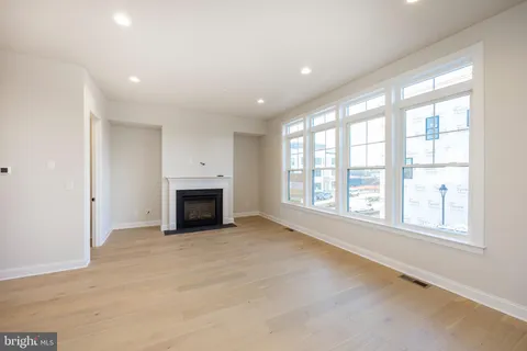an empty room with windows and fireplace