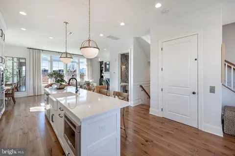 a large kitchen with granite countertop a stove and a wooden floors