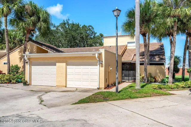a front view of a house with a yard and potted plants