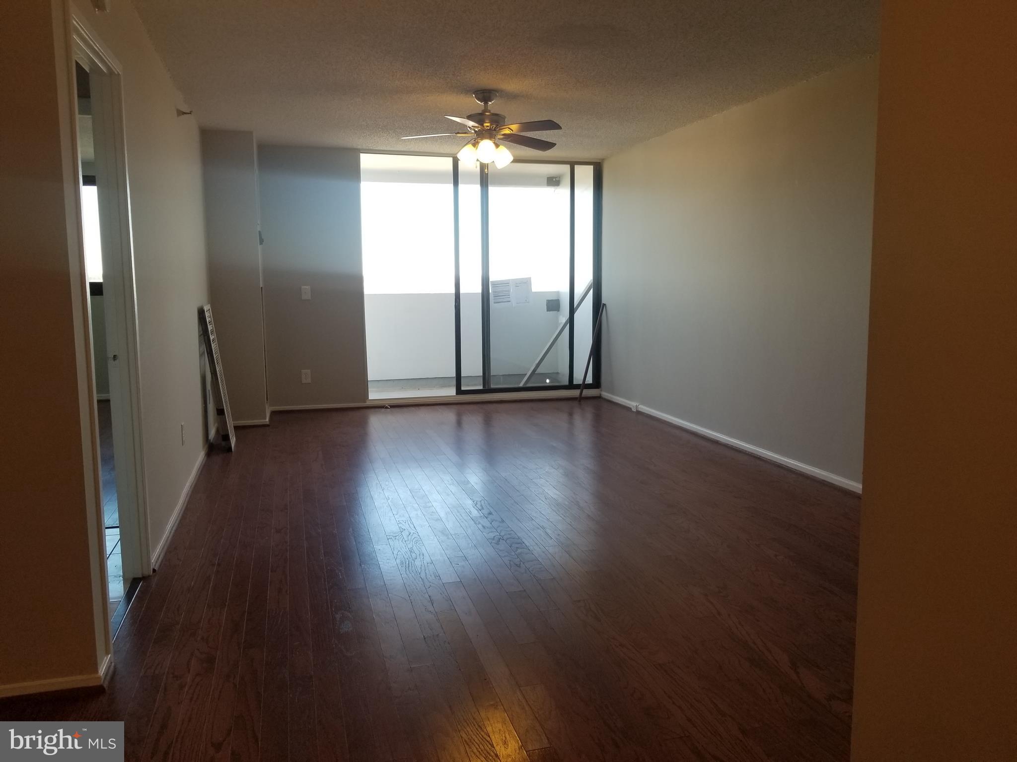 5911 Edsall Road, Unit PH09 Alexandria, VA 22304 - Photo 3 of 14 an empty room with wooden floor and windows