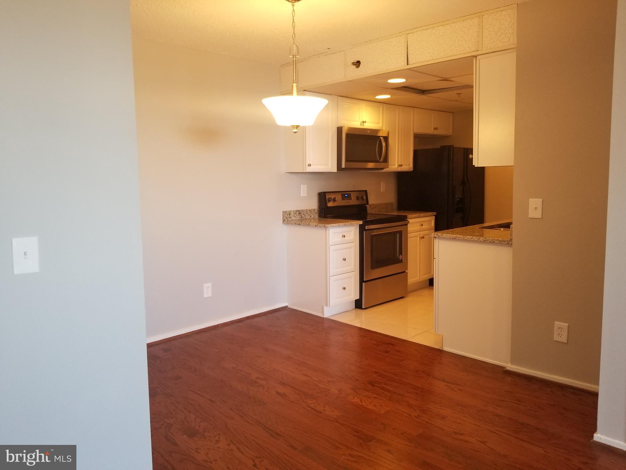 5911 Edsall Road, Unit PH09 Alexandria, VA 22304 - Photo 5 of 14 a view of a kitchen with a sink wooden floor and cabinet