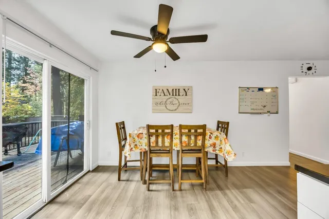 a kitchen with granite countertop a refrigerator a sink dishwasher a stove and white cabinets with wooden floor