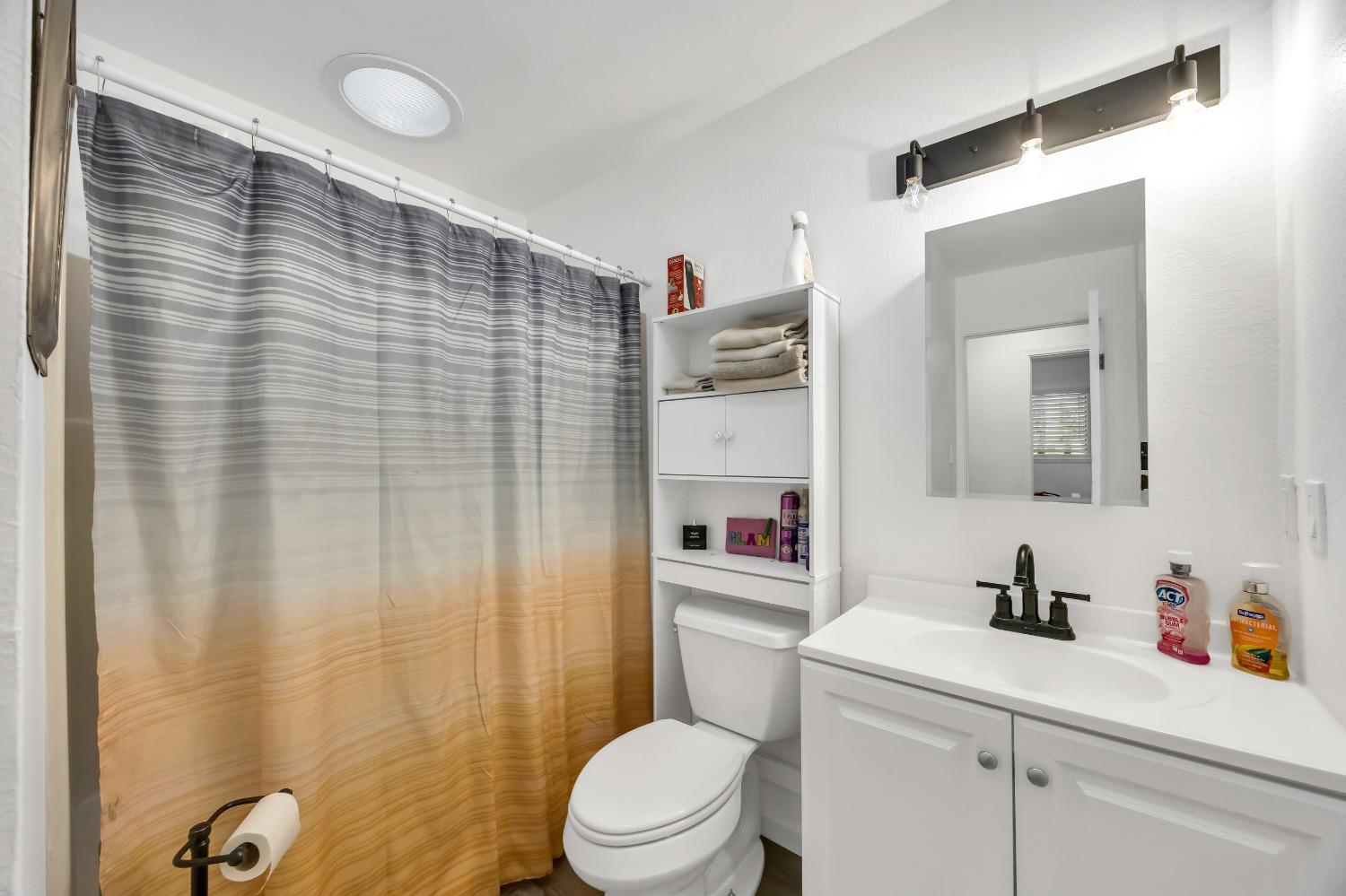 6922 Ridgeway Drive Pollock Pines, CA 95726 - Photo 24 of 44 a bathroom with a sink a toilet and shower curtain