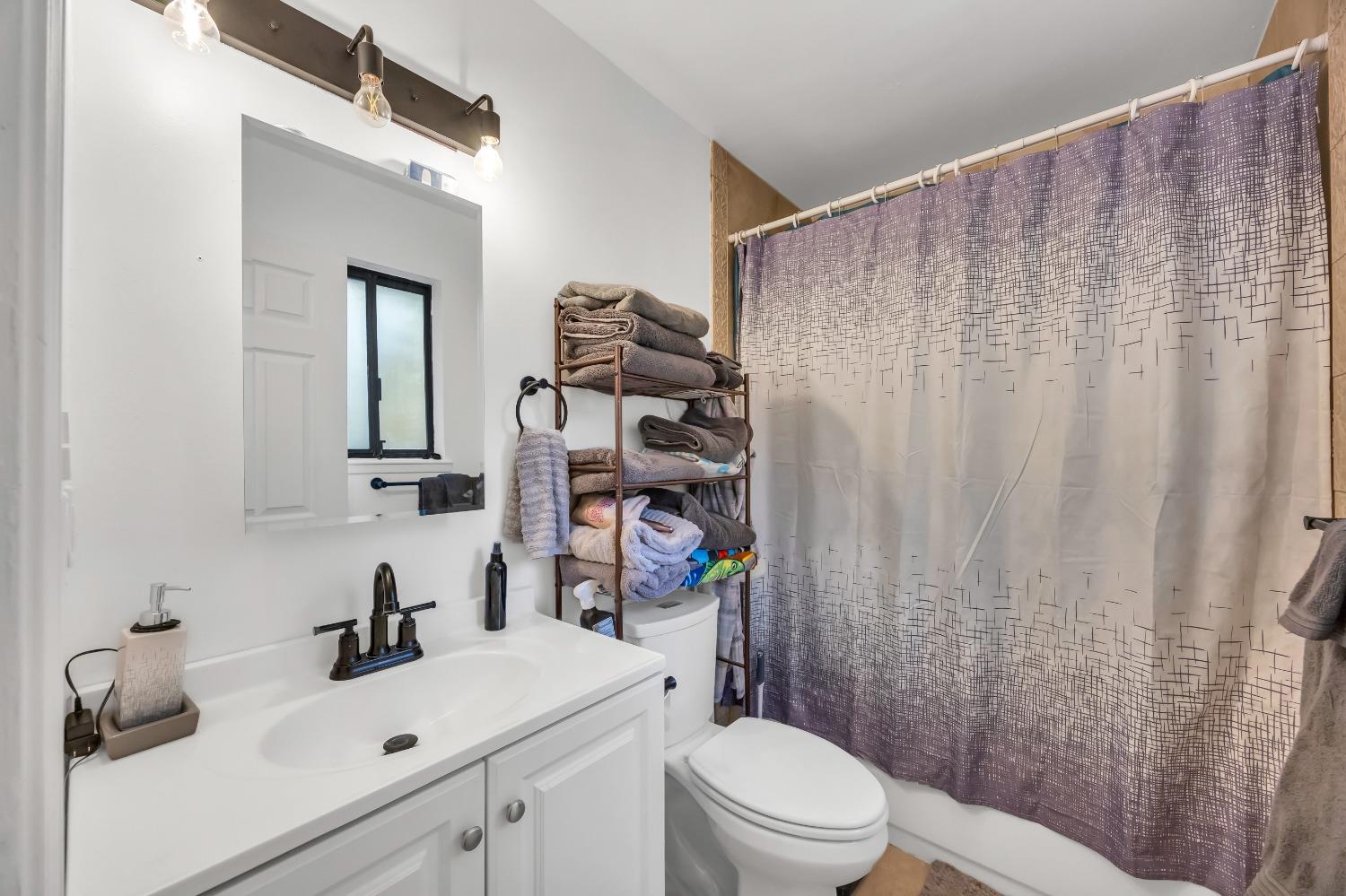 6922 Ridgeway Drive Pollock Pines, CA 95726 - Photo 28 of 44 a bathroom with a sink a toilet and shower curtain