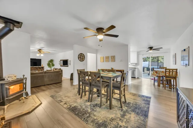 a living room with furniture a dining table and chairs with wooden floor