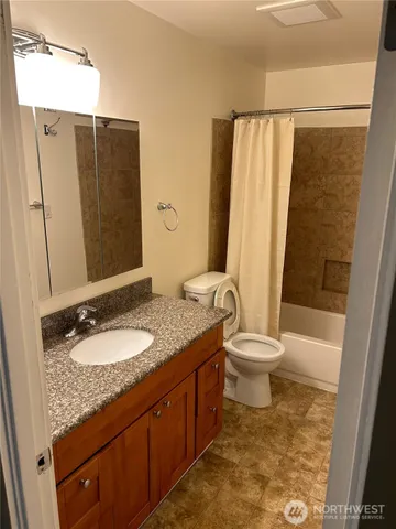 a bathroom with a granite countertop sink toilet and shower