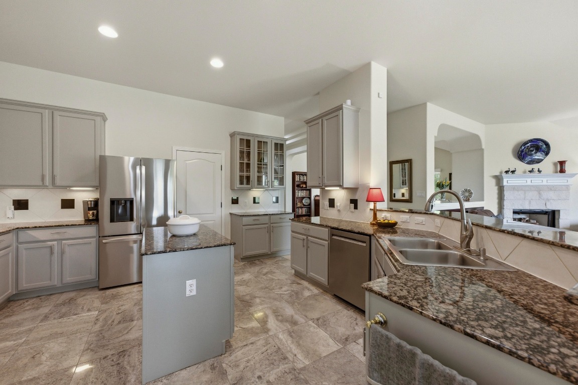 4705 Foster Ranch Road Austin, TX 78735 - Photo 7 of 40 a large kitchen with kitchen island a large counter top space a sink stainless steel appliances and cabinets