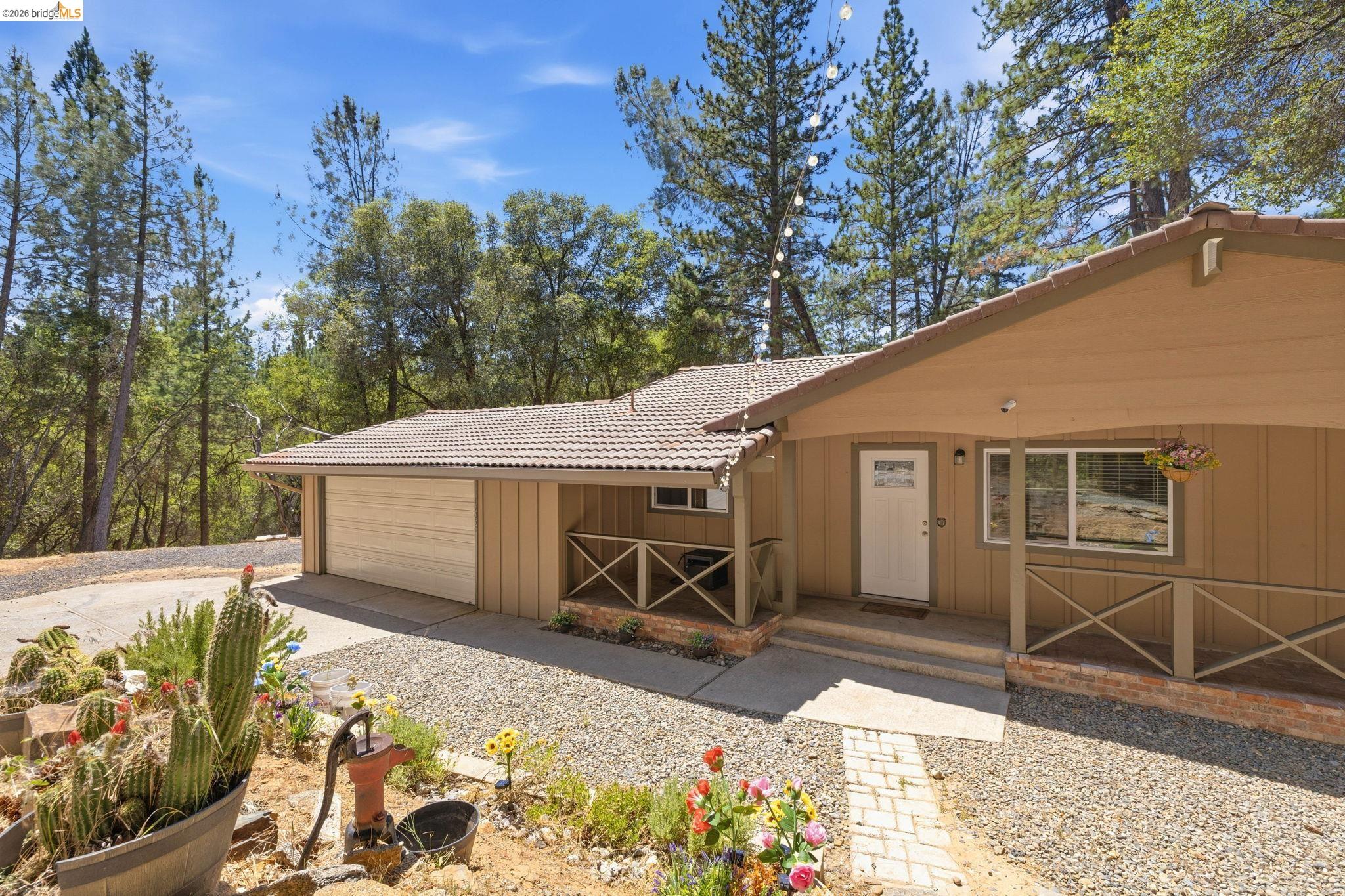 19059 Raboul Court Groveland, CA 95321 - Photo 3 of 21 Exterior featuring a covered front porch, an attached garage, and a tiled roof