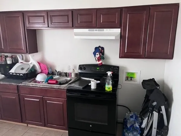 a kitchen with a granite countertop sink and a wooden floor