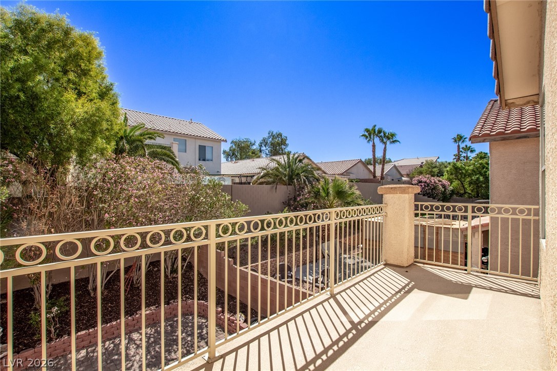 1477 Rancho Ridge Drive Henderson, NV 89012 - Photo 45 of 46 Unwind on this peaceful balcony, enjoying the vibrant greenery and distant desert-inspired rooftops.